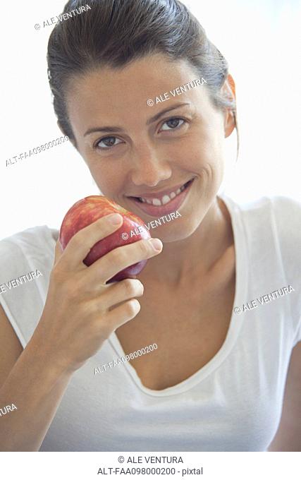 Woman holding apple, portrait