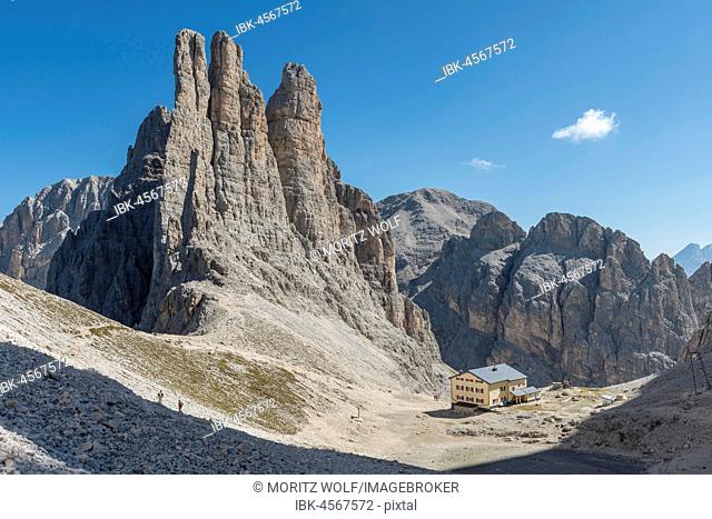 Descent from the Santner via ferrata, in front of Gartl hut, at the back climbing cliffs with Vajolett towers, Rosengarten group, Dolomites