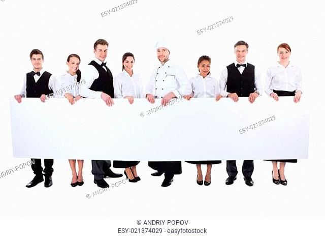 Group of catering staff holding a blank banner