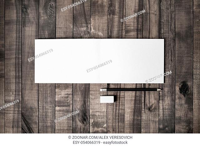 Blank notebook, pencil and eraser on vintage wood background. Stationery elements. Responsive design mockup. Flat lay