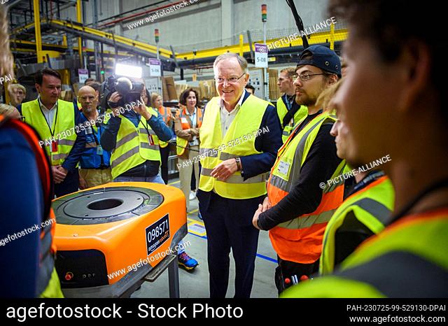 25 July 2023, Lower Saxony, Winsen (Luhe): Stephan Weil (M, SPD), Minister President of Lower Saxony, talks to trainees at the Amazon logistics center in Winsen...