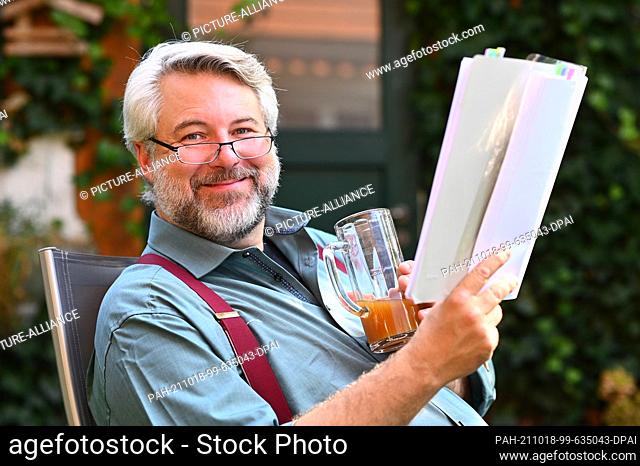 10 September 2021, Bavaria, Pöcking: Actor Dieter Fischer sits in his garden with a script and a juice spritzer. Photo: Lennart Preiss/dpa