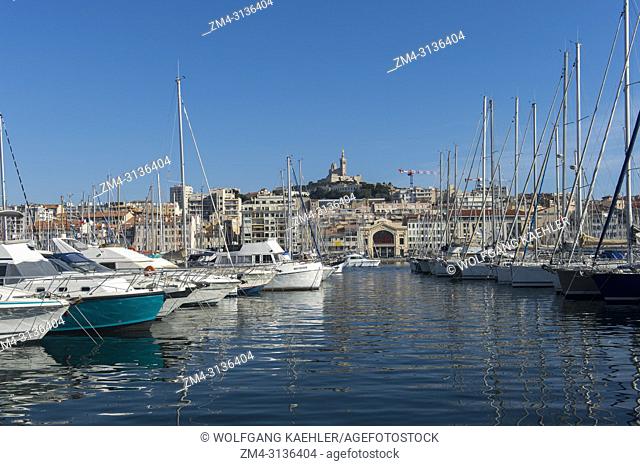 The Vieux Port (old port) with boats in Marseille, France with the Notre-Dame de la Garde (Our Lady of the Guard), a Catholic basilica in the background