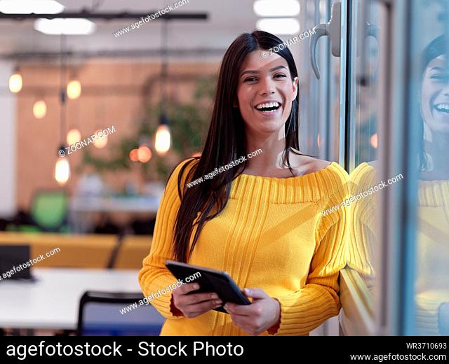 business woman portrait in open space startup coworking office as influencer using smart phone, tablet computer