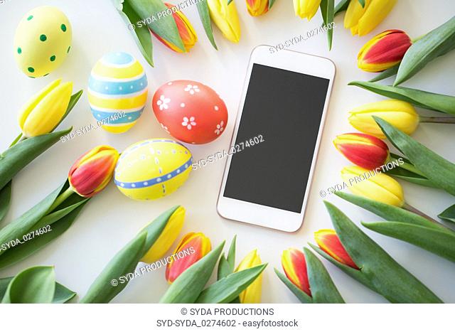 smartphone with easter eggs and tulip flowers