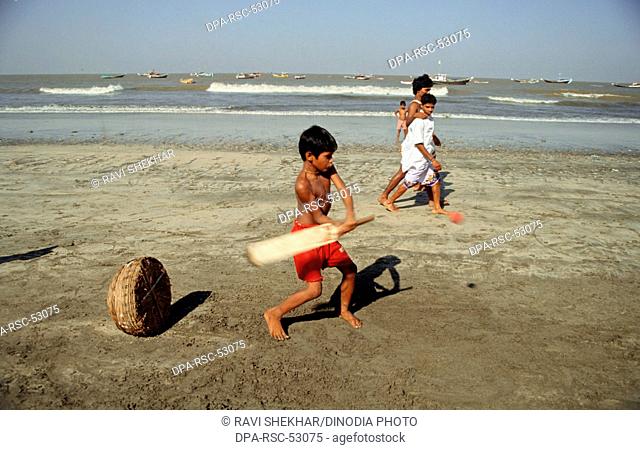 Boy playing cricket on beach
