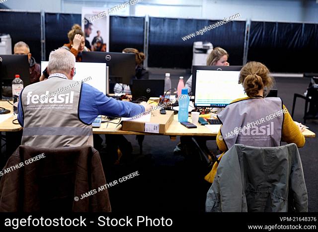 People pictured working at a center for the registration of Ukrainian refugees, at the Palace 8 hall of Brussels expo, Monday 14 March 2022