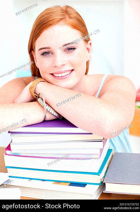 Smiling teee ger studying lots of books