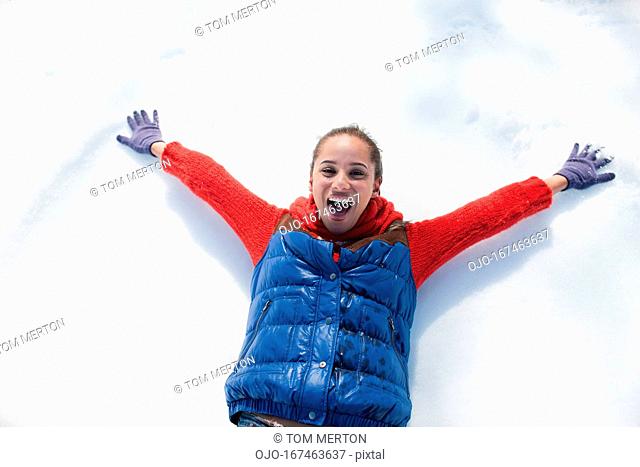 Smiling woman making snow angels