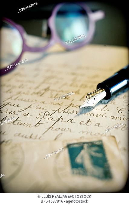 carta antigua manuscrita con sello de correos, pluma estilografica y gafas, old handwritten letter postmarked, pen stylographic and glasses