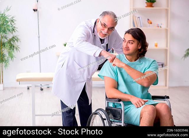 Young patient in wheel-chair and experienced doctor traumatologist
