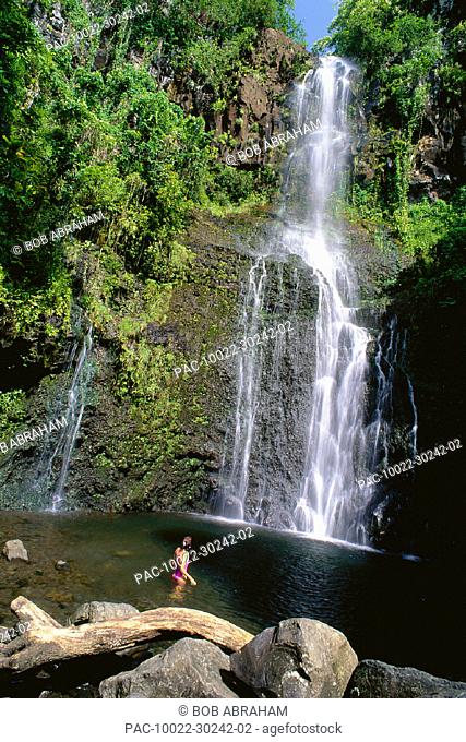 Maui pass Hana along Pi'lani Hwy, Woman in pool of Wailua Falls, view from behind