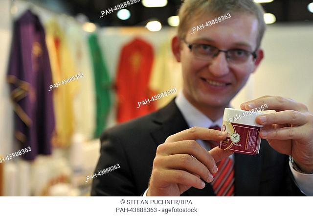 Daniel Dabrowski holds gluten-free communion wafers at a booth at the church trade fair 'Gloria' in Augsburg, Germany, 07 November 2013