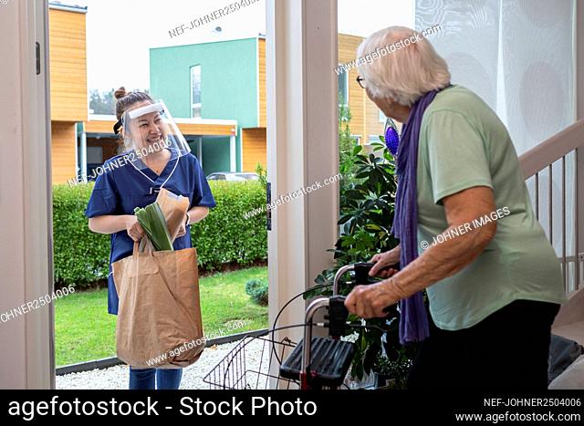 Home carer bringing senior woman shopping
