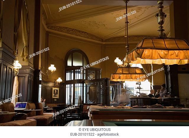 Mariahilf District Cafe Sperl the preferred cafe of Adolf Hitler. Interior with young woman using laptop in window alcove