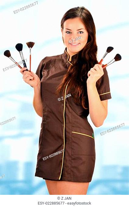 Professional beautician holding brushes