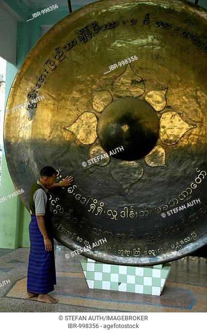 Man standing at a giant bronze gong, Mahamuni Pagoda, Mandalay, Burma, Myanmar, Southeast Asia