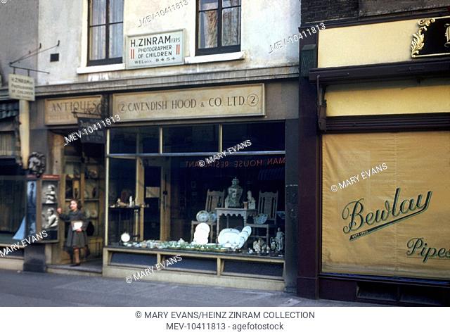 A view of Heinz Zinram's photography studio, above the Cavendish Hood antique shop at No. 2 Baker Street, London. Examples of his photography of children are on...