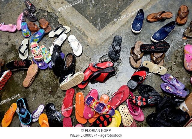 Indonesia, Aceh, Gampong Nusa, shoes in the rain in front of a community centre