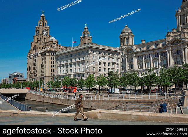 LIVERPOOL, ENGLAND, UK - JUNE 07, 2017: People enjoying the Port of Liverpool Building (or Dock Office) in Pier Head, along the Liverpool's waterfront, England