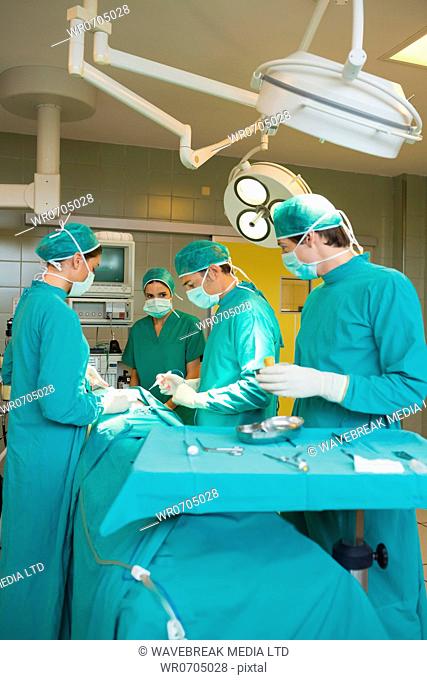 Surgeon team operating a patient in an operating theatre