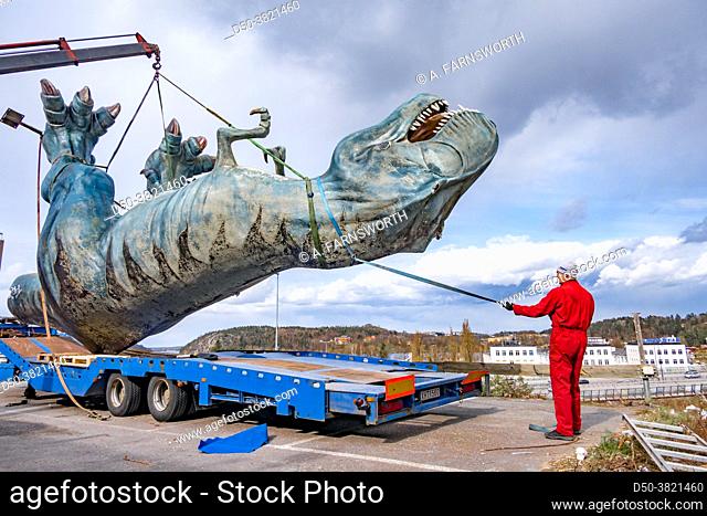 Stockholm, Sweden A large dinosaur figure is dismantled from a shopping mall amusement centre parking lot, (out of business) and is mounted on a truck for...