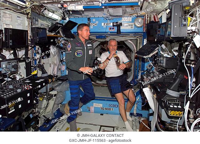 Cosmonaut Sergei K. Krikalev (left), Expedition 11 commander representing Russia's Federal Space Agency, holds a still camera and astronaut John L