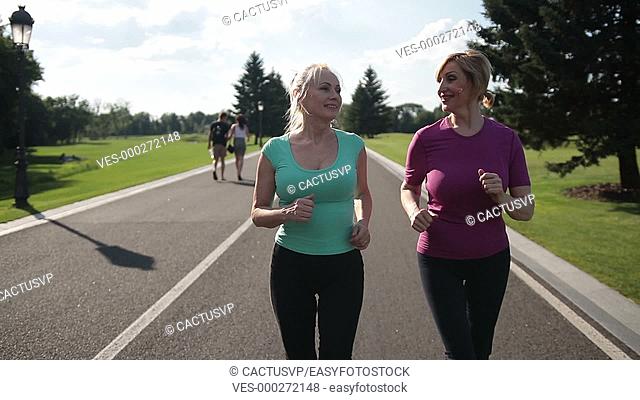Adult female joggers pursuing activity outdoors