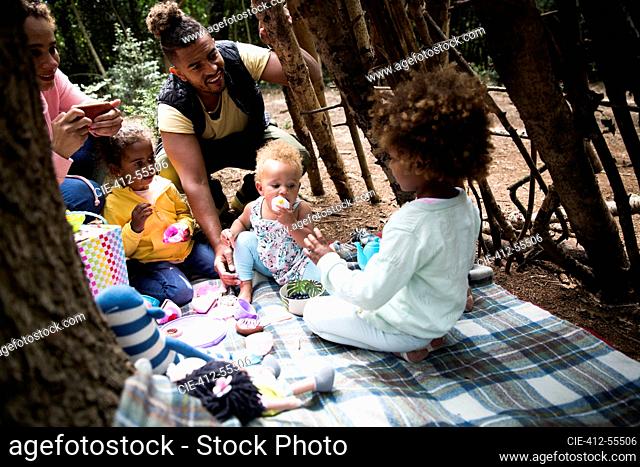 Family playing tea party in tree fort