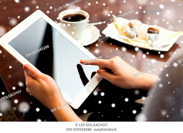 business, people and technology concept - close up of woman with tablet pc computer, coffee and dessert over snow