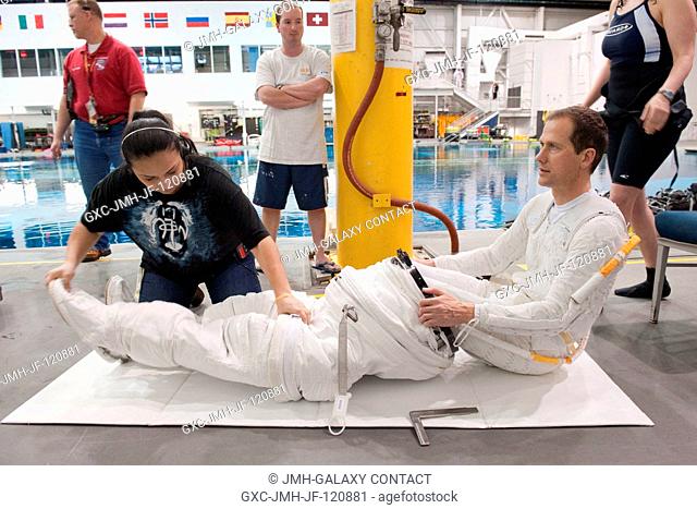NASA astronaut Tom Marshburn, Expedition 3435 flight engineer, dons a training version of the Extravehicular Mobility Unit (EMU) spacesuit in preparation for a...