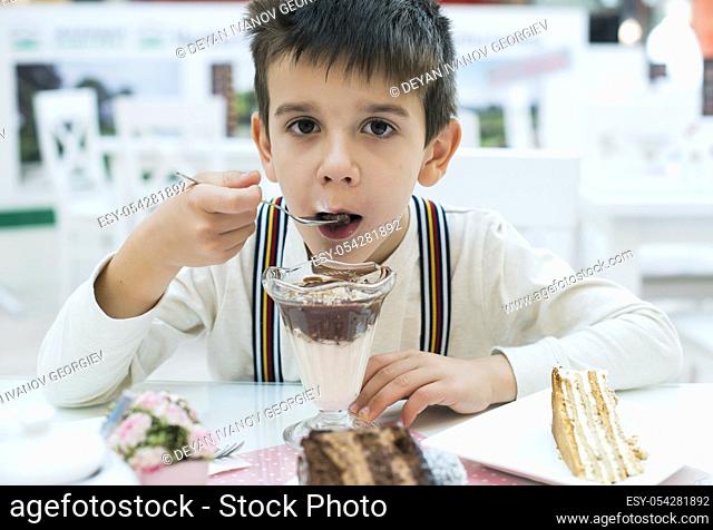 Child eat milk choco shake on a table