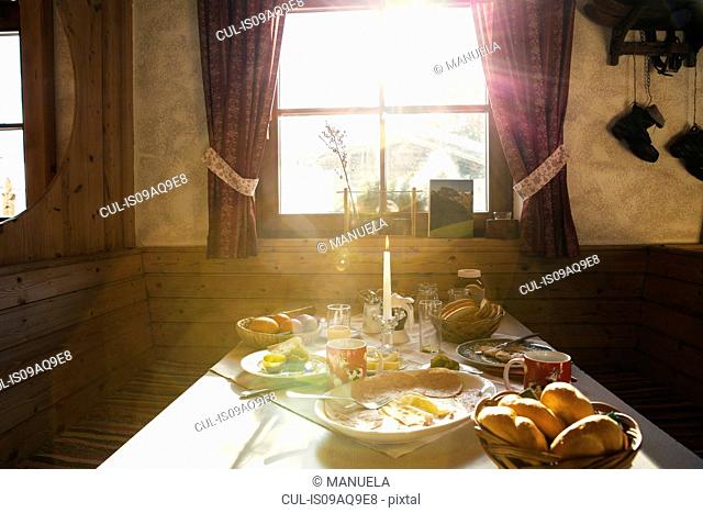 Sunlit breakfast table in log cabin