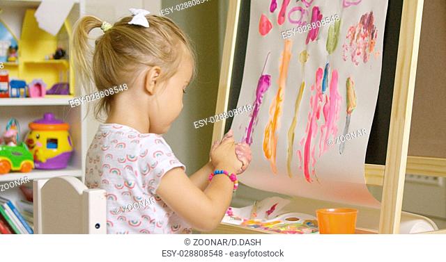 Creative little girl painting an abstract picture