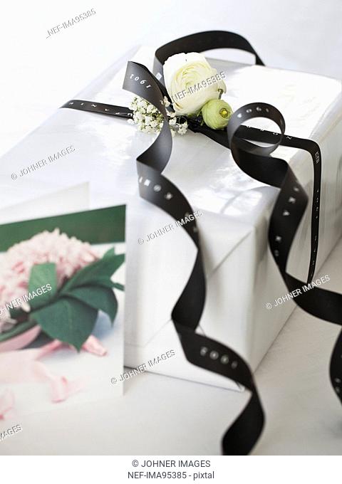 White gift box with black ribbon