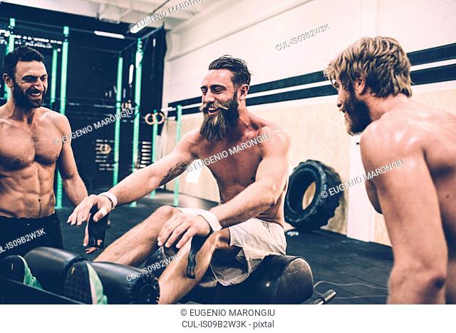 Three male cross trainers chatting in gym