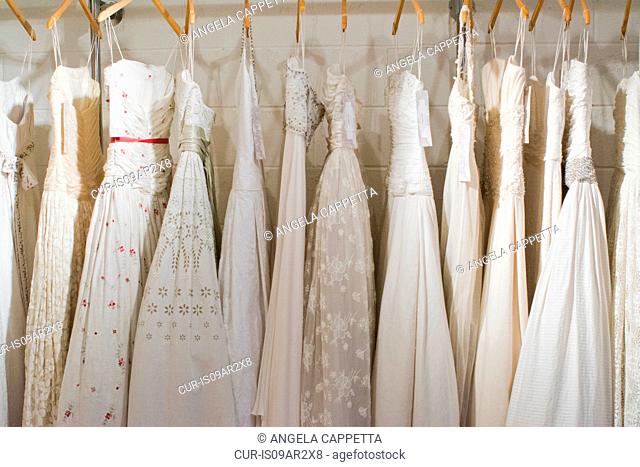 Row of hand made wedding gowns on display in boutique
