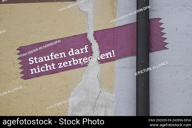 05 March 2020, Baden-Wuerttemberg, Staufen: Above the crack in a house façade there is a poster with the inscription ""Staufen must not break""