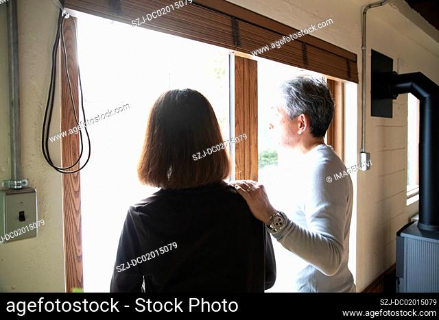 Senior couple talking by window