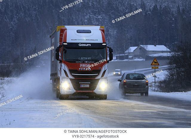 Salo, Finland - December 22, 2018: Biogas fueled Iveco Stralis NP truck L. Retva Oy pulls FREJA trailer along snowy highway in winter evening traffic