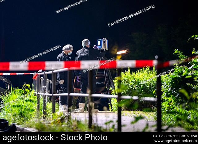 26 August 2023, Hamburg: Forensic technicians work with a 3D scanner at the cordoned-off crime scene. In the Hamburg district of Borgfelde