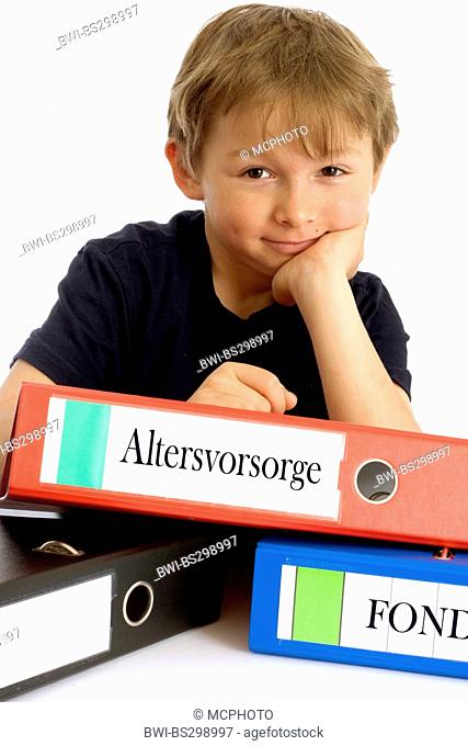 little boy smirking while leaning on a file with the inscription 'Altersvorsorge' ('retirement planning')