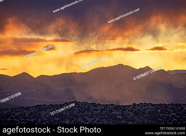 USA, New Mexico, Lamy, Galisteo Basin Preserve, Cloudy sky over mountain landscape at dusk