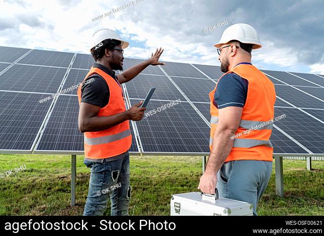 Multiracial colleagues discussing at solar station