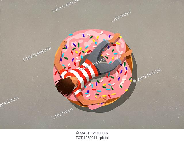 Girl relaxing on large donut with sprinkles