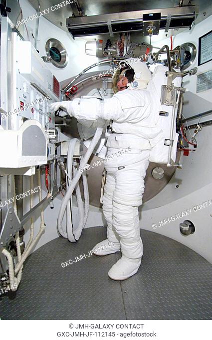 Astronaut Michael E. Fossum, STS-124 mission specialist, participates in an Extravehicular Mobility Unit (EMU) spacesuit fit check in the Space Station Airlock...