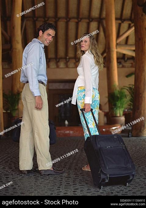 Hispanic couple arriving at hotel