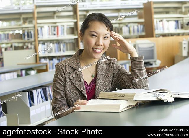 Asian woman with books in library