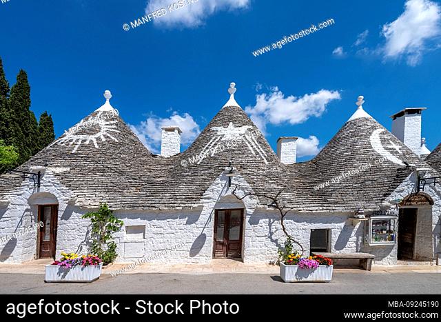 Alberobello, Bari province, Salento, Puglia, Italy, Europe. The typical trulli houses with their cone-shaped roof and the symbols