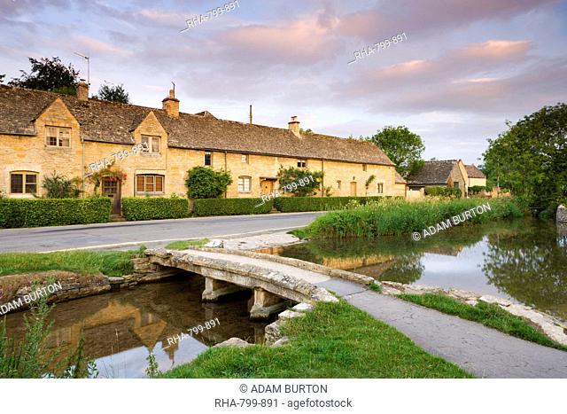 Cottages and stone footbridge in the Cotswolds village of Lower Slaughter, Gloucestershire, England, United Kingdom, Europe